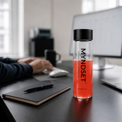 MYNDSET energy drink bottle on a desk with a person working in the background
